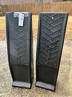Front view of two black plastic ramps showing tread surface design.