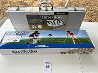 Both game sets side by side on a white table in outdoor setting with fall leaves visible.