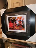 Full frontal image of the framed art print with protective corner covers showing the colorful landscape artwork.