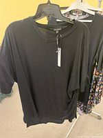 Black V-neck short sleeve top on hanger with tag visible, from Daniel Hechter