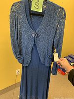 Blue lace cardigan hand-held with matching inner dress, showing texture and button detail