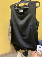 Black sleeveless designer top hanging, smooth fabric