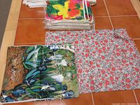 Paper gift bags laid out on floor showing nature design with birds and floral print bag with red flowers and white background