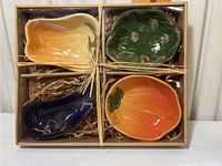 Set of four decorative ceramic bowls in a box with twine tie and filler.