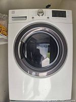 Front view of white Kenmore electric front-loading dryer with closed door