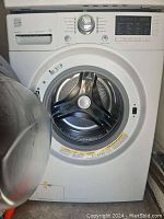 Front of washer with door open showing stainless steel drum interior.