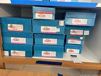 Shelf with stacked original blue Madame Alexander Storyland doll boxes