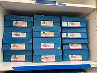 Shelf of 11 original blue Madame Alexander boxes labeled International Collection.