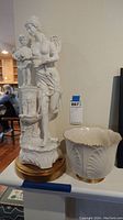 Full view of porcelain statue of mother and child next to Lenox planter on shelf, showing the scale and materials.