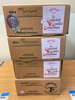 Image showing four original Robin Woods Camelot Castle Collection doll boxes stacked, labeled Lady Elaine, Young Lancelot, Amuse, Romeo.