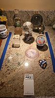 Overview of the collection showing all art glass items and decorative bottle on a granite countertop