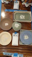 Photo shows five Wedgwood Jasperware pieces placed on a wooden table including three small plates, a heart-shaped jewelry box, and a rectangular tray in a box.
