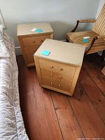 Two light wood nightstands positioned near a bed and a wooden chair, showing their overall appearance and protective glass tops.