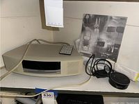 Bose Wave Music System with remote and Alexa device on shelf