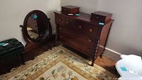 Full view of dresser with two small top side drawers and larger main section, mirror leaning against wall to the side, all items with tags.