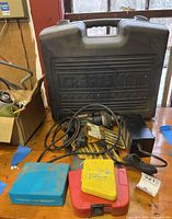 Craftsman Professional trim saw in closed carrying case with power tools and drill bit sets arranged on wooden table