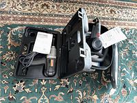 Craftsman Professional Impact Wrench in hard plastic carrying case alongside the dual-action buffer polisher with handle on a patterned carpet.