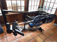 Side and top angled views of black metal Teeter Hang Ups medical inversion table showing padded ankle supports, adjustable safety straps, and perforated backrest with headrest.