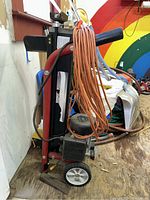 Front and side view of folded Southland log splitter with orange extension cord coiled on handle