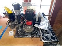 Craftsman router with power cord coiled, dust collector box and two boxes of router bits visible