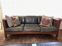 Front view of sofa showing full frame, seat and back cushions, and throw pillows