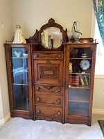 Front view showing central mirror, drop-front door, drawers and both glass-door cabinets
