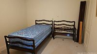 Assembled twin bed frame with mattress in basement room