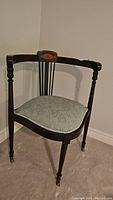 Front side view of Edwardian mahogany corner chair showing curved backrest, armrests, and upholstered seat.
