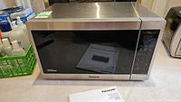 Front view of Panasonic stainless steel microwave with black front and control panel on right side