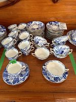 Overview of stacked cups and saucers on wooden surface