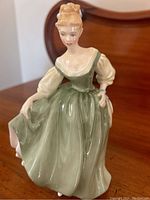 Front view of the Royal Doulton Fair Lady figurine showing detailed green and cream dress and delicately painted face.