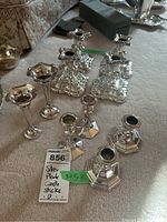 Overview of all six silver plated candleholders grouped together, showing different designs and sizes