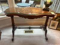 Full front view of walnut burl table with glass top