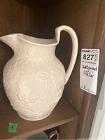 Front angle view of the white Wedgwood porcelain pitcher showing floral relief design and curved handle.