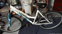Side view of the full white Pacific Cycle bicycle showing frame, tires, and pedals