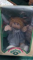 Front view of the 1985 Cabbage Patch Kids doll Kate Trina in original box showing the doll and logo.