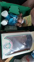 Photo showing doll in original box with tags and certificate