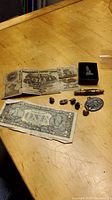Overview of paper money, medallion, pins arranged on table