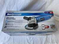 Photo of the closed original box showing Mastercraft branding, product image of angle grinder, and key features printed on the box.