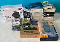 Overview of lot showing Thermaltake TR2 600W power supply box, multiple LG DVD drives, Creative sound cards, 4 x 3.5 inch internal HDDs in ESD bags, floppy disks pack, and other items.