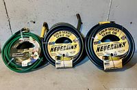 Three garden hoses shown together: two dark blue Neverkink Gold Series hoses, each 5/8" x 110', and one green Yardworks heavy duty vinyl hose 5/8" x 50'.