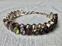 Front view of bracelet showing marquise cut gemstones in various colors set in sterling silver.