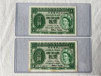 Two 1959 Hong Kong British one dollar bills placed in clear vinyl holders, showing front sides of both notes.