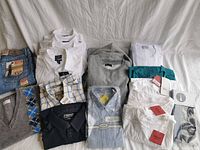 Photo of assortment of men's clothing including shirts, sweaters, and t-shirts showing size and variety