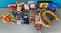 Photo showing full lot of assorted children's toys and collectibles including steering wheel toy, plush toys, playing cards, figurines and packaged items.