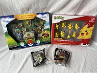 Full lot showing the Pokémon trading card special collection box, Pikachu figure multi-pack, and two McDonald's Pokémon toys Axew and Pignite in sealed original packaging.