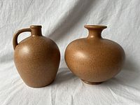 Pair of two Blue Mountain Pottery vases shown side by side on fabric with neutral background.