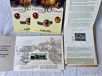Photo of two packages of Christmas Your Own Sticker stamps along with a 64-cent locomotive stamp and a historical pamphlet.