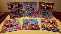 Front view of all six Look and Find hardcover books laid out on a table, featuring superhero and animated character themes.