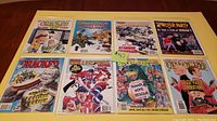 Top-down photo showing all 8 Cracked magazines laid out in two rows on a table. Each magazine is bagged and boarded with visible colorful cartoon covers featuring various parodies and themes.